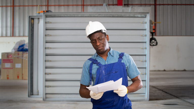 A construction worker studies a new tax form